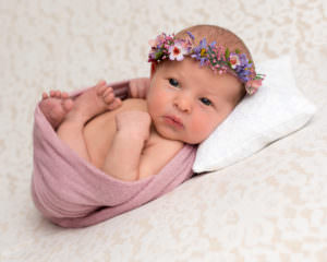 Newborn photoshoot baby girl in pink on lace blanket. Part of a gallery from newborn photography shoot in Glasgow