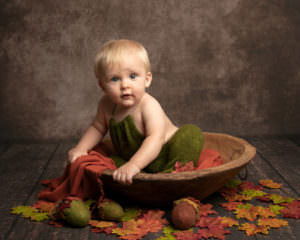 baby photography session baby in bowl with autumnal leaves
