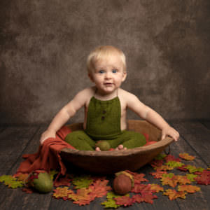 baby photography session baby in bowl with autumnal leaves