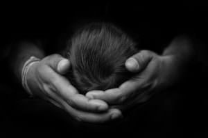 arty black & white image of baby head in dads hands at Glasgow photography studio