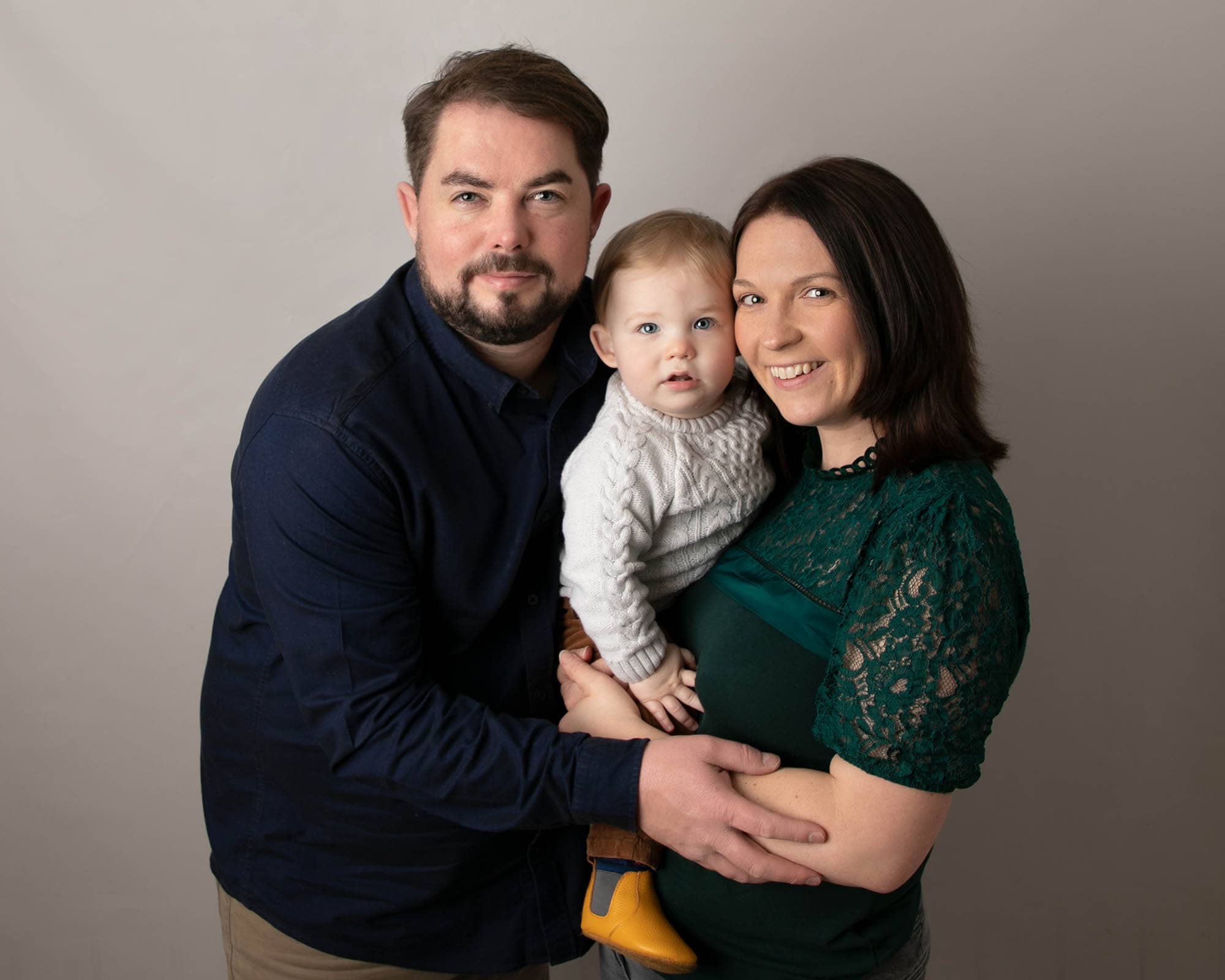 Family portrait of mum, dad and little baby boy. Image taken at Glasgow studio during baby photography session