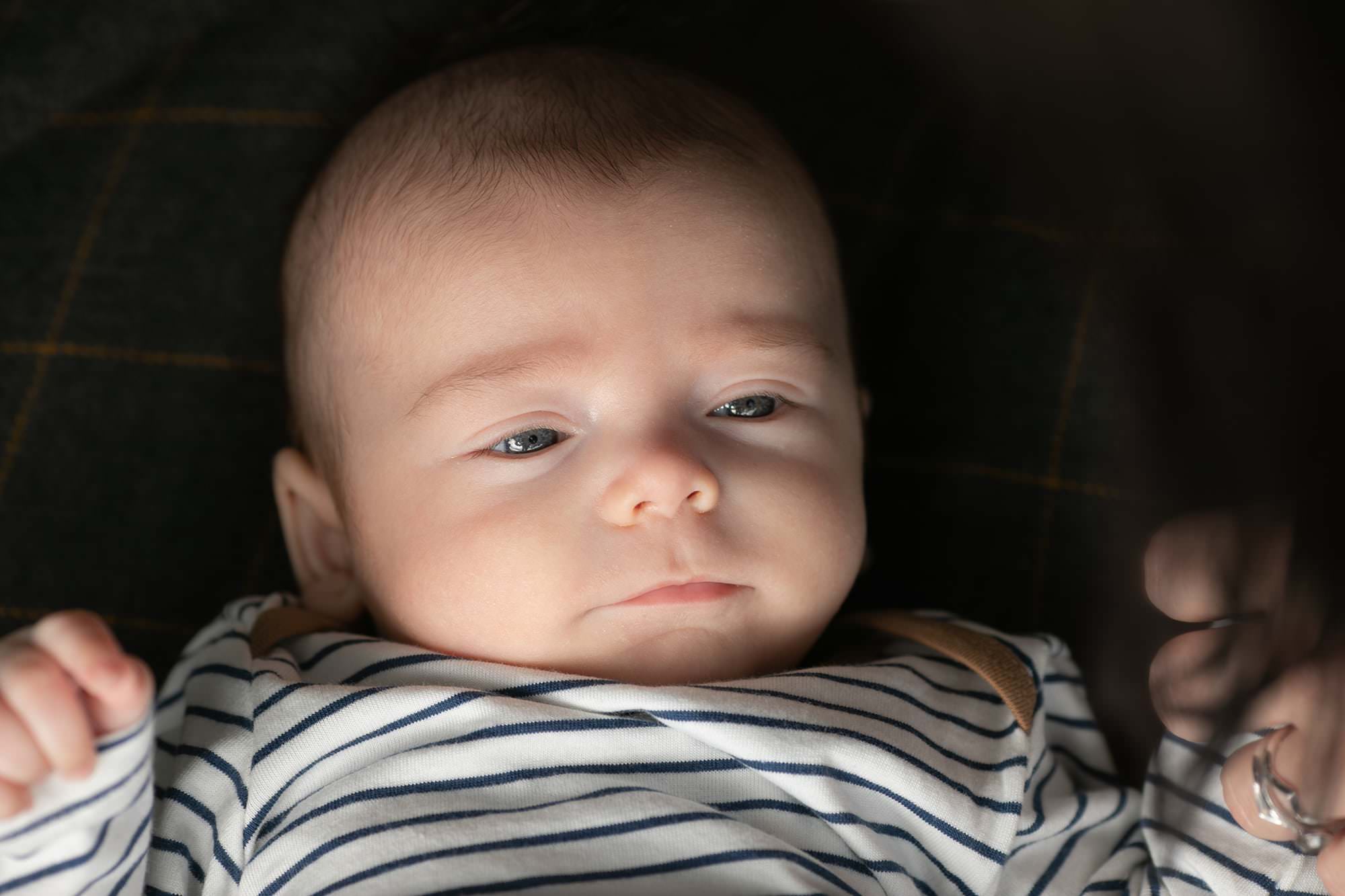 Baby boy lying on a rug. Close up of face during outdoor family photography session in Glasgow