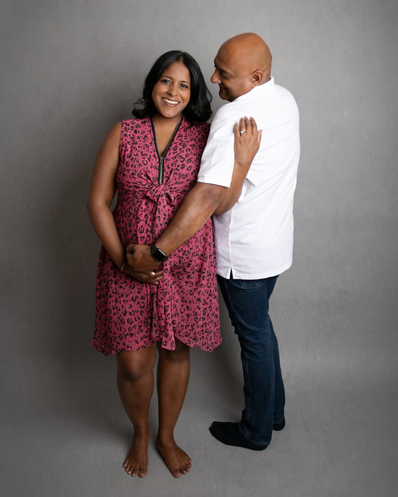 Pregnant female with male partner. Female wearing pink & black dress. male wears jeans and white shirt. Images taken by Glasgow Maternity Photographer