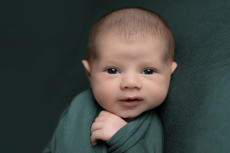 Baby wrapped in green looking at the camera, taken by Louise Ferguson Glasgow Newborn baby Photography
