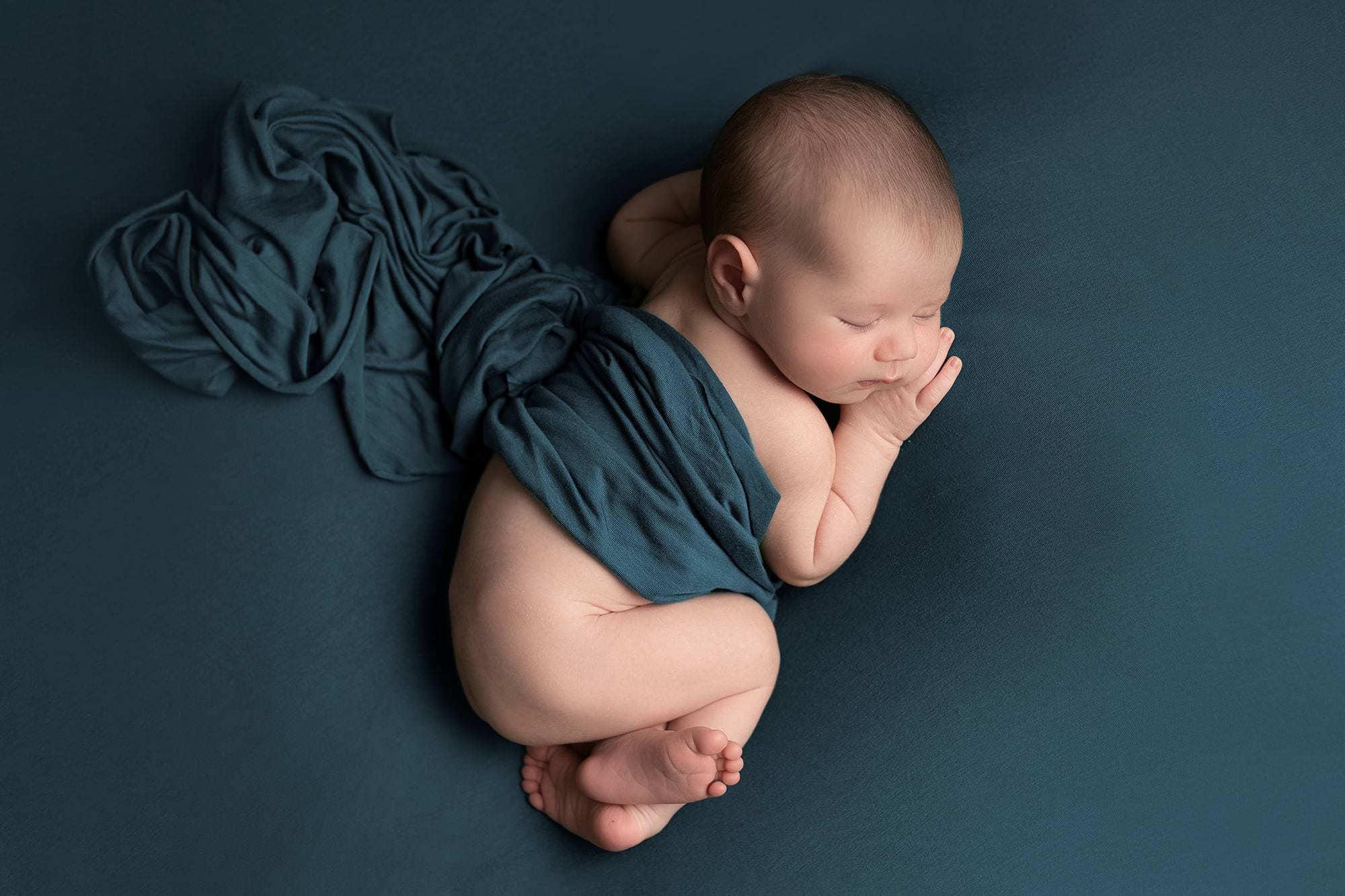 Baby boy sleeping on blue blanket at newborn photography session at Glasgow photography studio